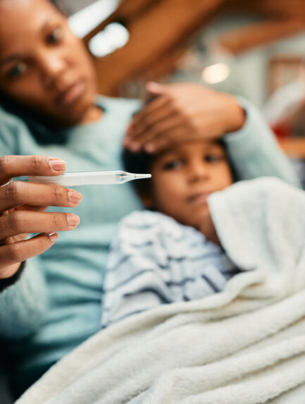 A mother checking her son for a fever with a thermometer