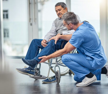 helping a man in a wheelchair