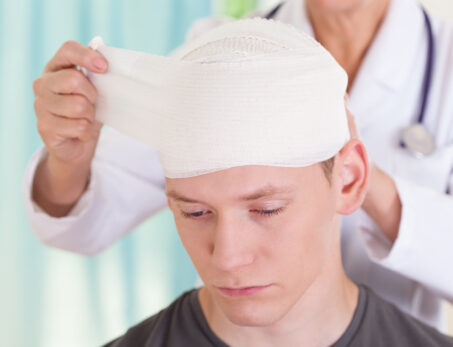 Doctor removing a head bandage from the patient