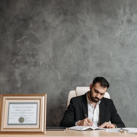 Photo by Pavel Danilyuk: https://www.pexels.com/photo/man-wearing-black-suit-writing-in-the-notebook-8112105/