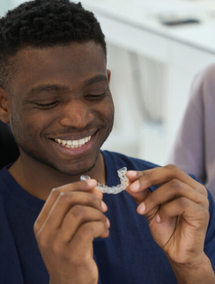Young man wearing clear braces in order to get rid of malocclusion
