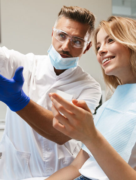 Happy young woman sitting in medical dentist center looking at x-ray scan.
