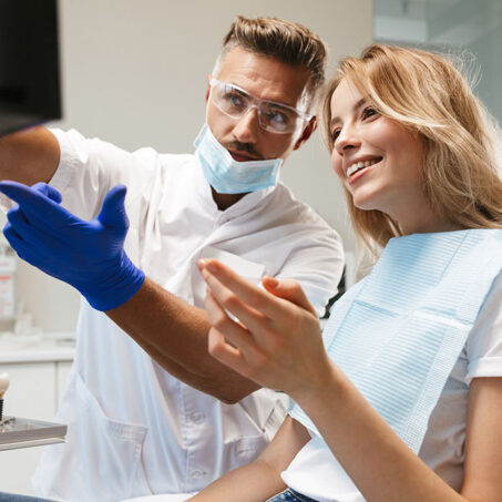 Happy young woman sitting in medical dentist center looking at x-ray scan.