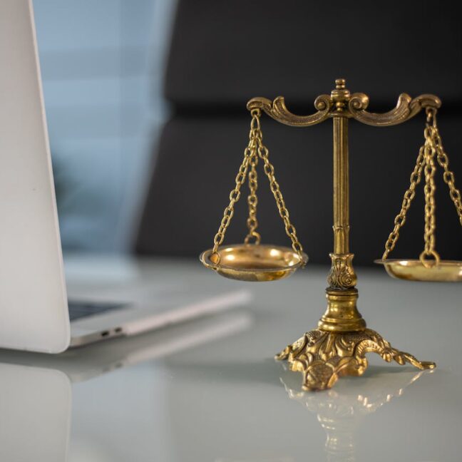 Photo by KATRIN BOLOVTSOVA: https://www.pexels.com/photo/a-golden-balance-scale-beside-a-laptop-6077797/