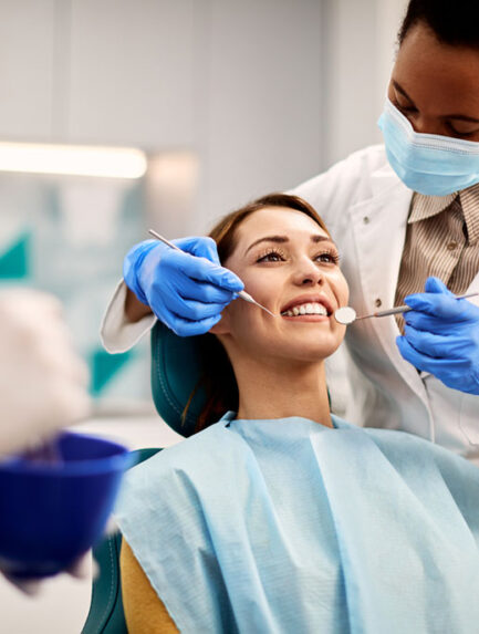 Young smiling woman having dental exam at dentist's office.