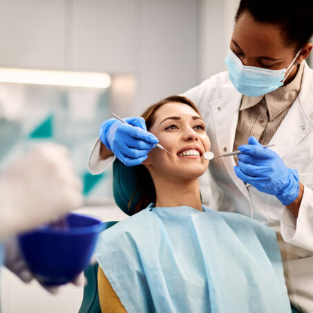 Young smiling woman having dental exam at dentist's office.