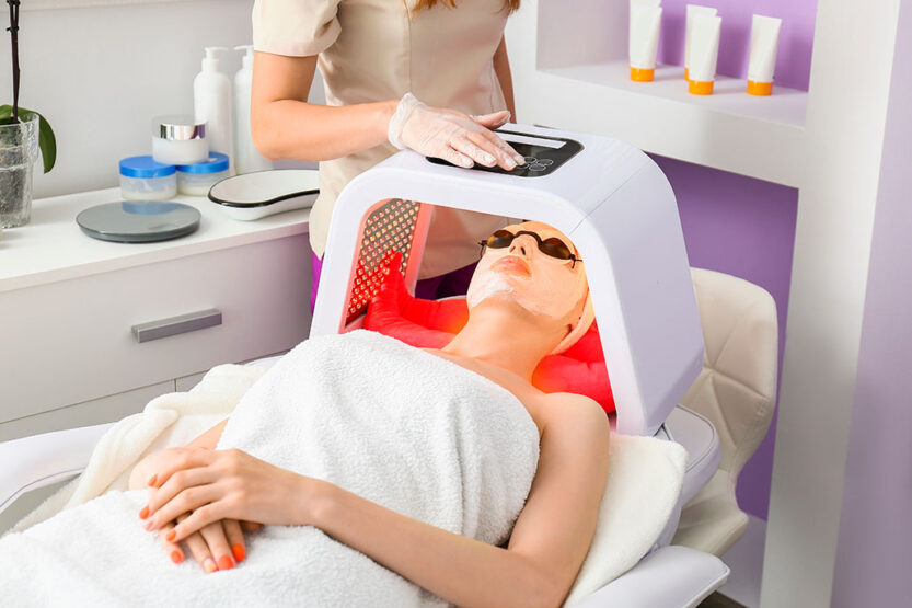 Woman undergoing procedure of facial light therapy